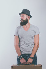 Portrait of handsome bearded man in hat standing with bag, isolated on white background