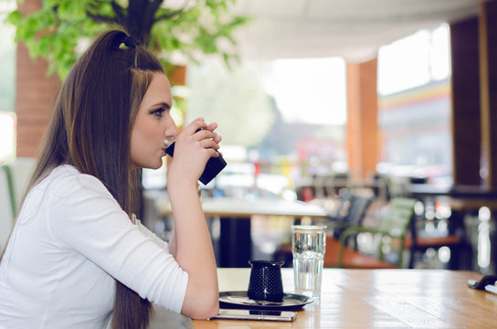 Girl sits on the side and enjoy your morning coffee at the coffee shop