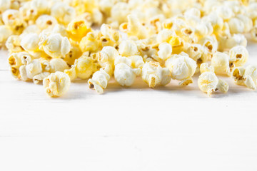 Salted popcorn on a white table. Top view. Empty space for text.