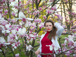 beautiful girl among magnolia pink blossom sping tree flowers