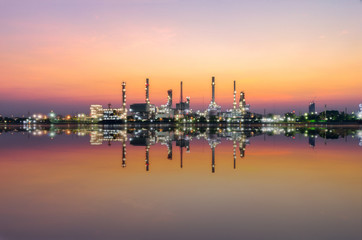 oil refinery industry at morning with water reflection.