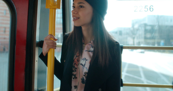 Pretty woman standing on a city traim and sightseeing.