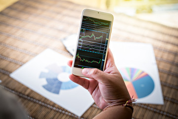 Woman showing smartphone Chart on screen