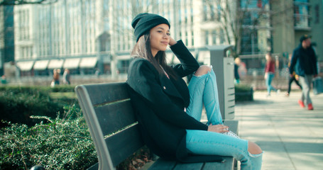 Young beautiful african american woman sitting on a bench.