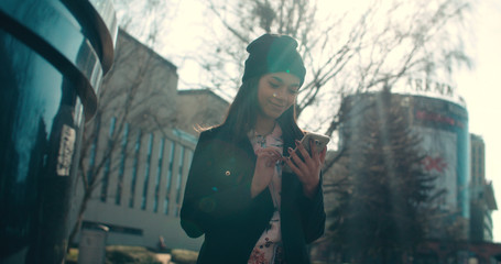 Portrait of young African American woman using phone, outdoors.