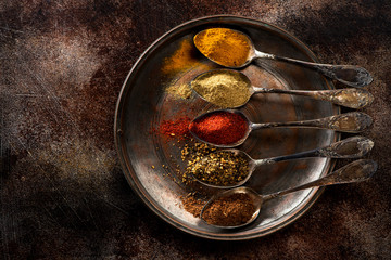 Spices and herbs in old spoons