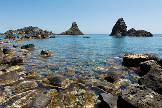 Cyclops islands, Acitrezza, Sicily. Basalt rocks on the sea