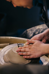 Potter models shape to a clay ware