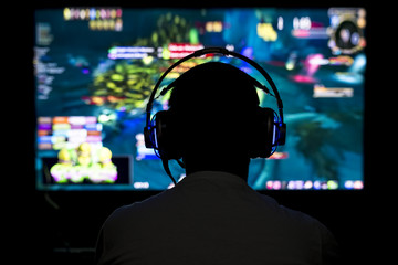 Young gamer playing video game wearing headphone. © sezer66
