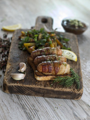Fried sausages with bacon on a wooden board. 