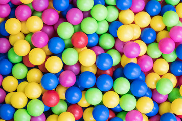 Background of children multi-colored plastic balls on a rubber backing