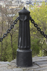 Obraz na płótnie Canvas Cast iron column with chains as a fence. 