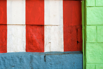 Red, white, green and blue wall texture background with stripes