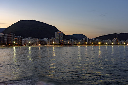 Copacabana Beach and Sugar Loaf seen at night with its buildings, lights, sea, hills and contours