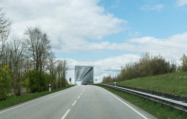 auf der landstrasse alleine auf eine alte brücke zu fahrend