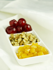 Candied orange and cherries with walnut in a white plate