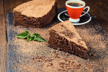 chocolate cake with Candies and cup of coffee,Chocolate cake with a cut piece and blade on gray background,closeup,Dark chocolate cake,vegan chocolate cake,Tasty chocolate cake on wooden background