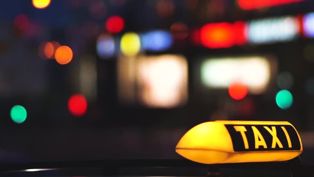 Sliderfahrt Taxischild Nachts in einer Gro&szlig;stadt mit Bokeh