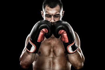 Sportsman Muay Thai boxer celebrating flawless victory in boxing cage. Isolated on black background...