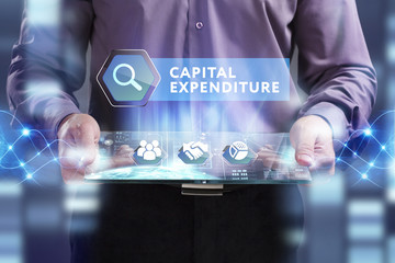 Business, Technology, Internet and network concept. Young businessman working on a virtual screen of the future and sees the inscription: Capital expenditure