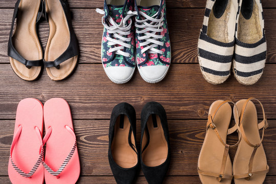 Collection of women's shoes on wooden background