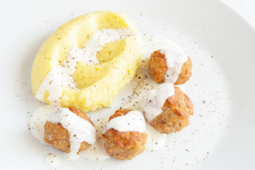 turkey meatballs and potato under bechamel sauce sprinkled with black pepper