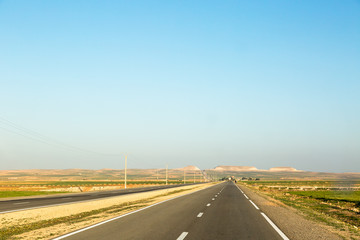 Very long straight highway in Morocco with low horizon