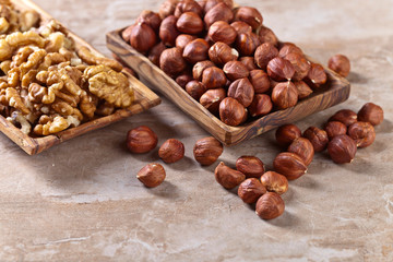 Hazelnuts and walnuts in old wooden dish