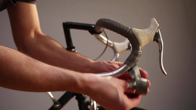 Man changing bar tape for road bike.