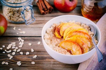 Healthy breakfast: oatmeal bowl with caramelized peaches, cinnamon and honey