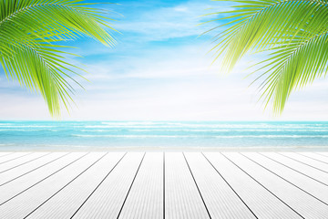 Empty wooden table and palm leafs with party on beach background blurred. Concept Summer, Beach, Sea, Relax, Party.