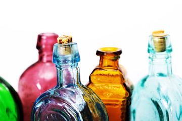 Old colourful bottles against a white background