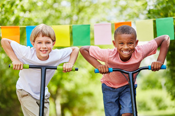 Zwei Kinder mit Roller sind ehrgeizig