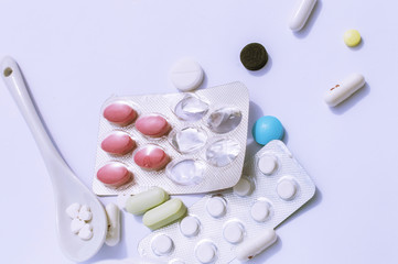 tablets on a spoon close-up on a white background