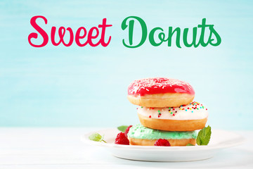 Plate with stack of delicious donuts and berries on white blurred background