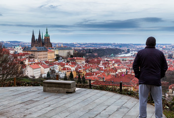 Unrecognizable tourist man enjoying great panoramic view oo the old town of Prague. Concept of Europe travel, sightseeing and tourism. Czech Republic.