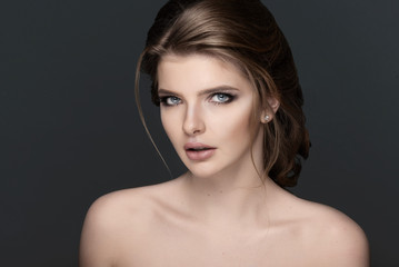 Studio portrait of a beautiful young woman with brown hair.