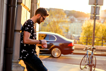 Young man waiting on the sunny street  