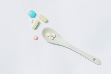 tablets on a spoon close-up on a white background