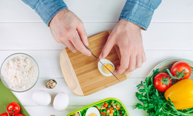 Close up top view of males hands cutting egg for lunch box