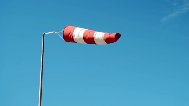 Slow motion of a weather vane swinging in a strong wind