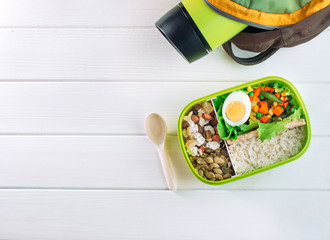 Lunch box with spoon and thermos mug on white background with copy space