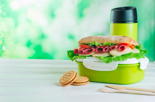 Lunch box with sandwich on white wooden background with copy space