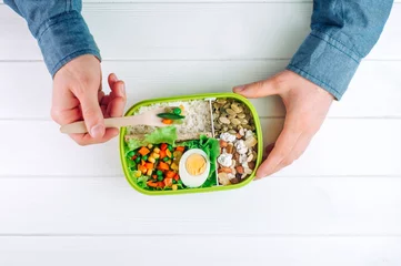 Foto op Canvas Males hands holding lunch box to eat rice, mixed vegetables, boiled egg © lithiumphoto