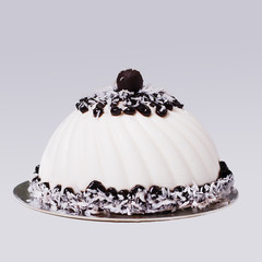 French mousse cake with chocolate decoration and coconut. White modern European dessert