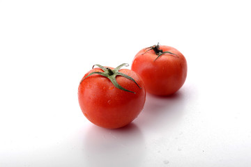 Two tomatoes isolated on white background