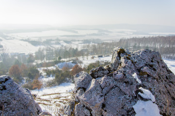 Skały na szczycie góry na tle wschodu słońca zimową porą, Kielce, Polska