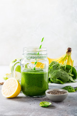 Healthy breakfast with green smoothie in glass jar and ingredients. Detox, diet, healthy, vegetarian food concept with copy space.