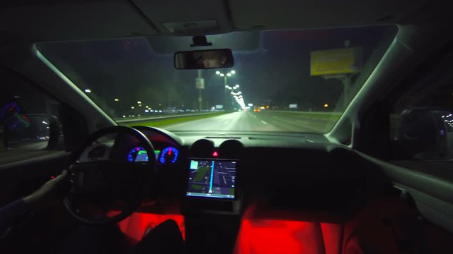 The man drive a car on the night highway. inside view. wide angle, real time capture