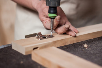 Close op picture of hands working with drill on wood